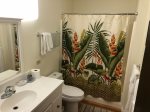 The downstairs bathroom features island botanical linens.